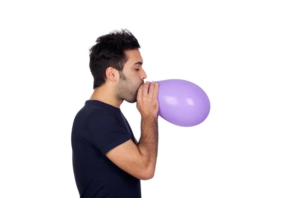 Attractive young men swelling a purple balloon — Stockfoto