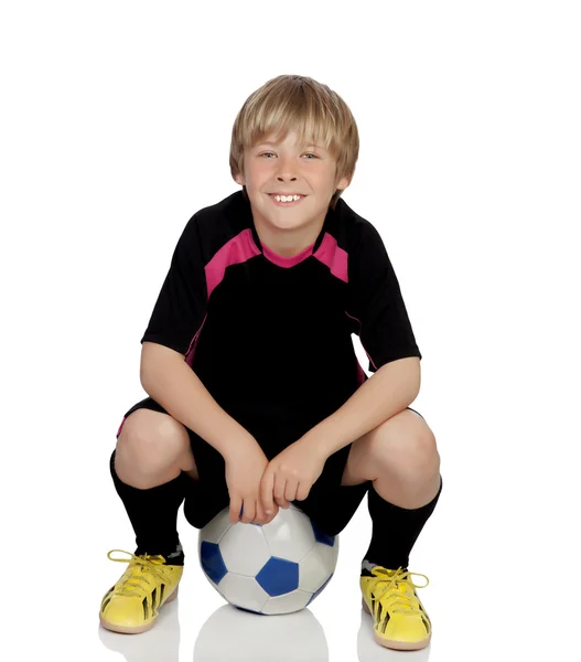 Preteen mit Uniform zum Fußballspielen auf einem Ball sitzend — Stockfoto