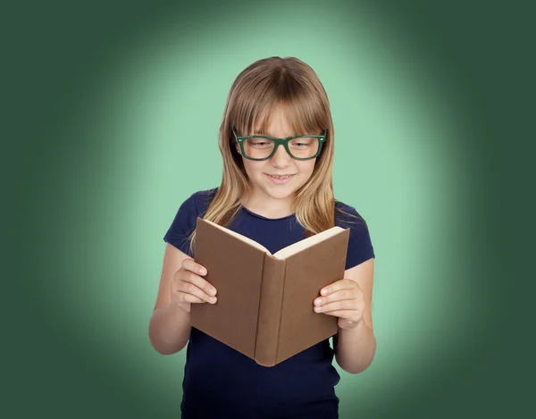 Beautiful little girl with glasses and a book reading