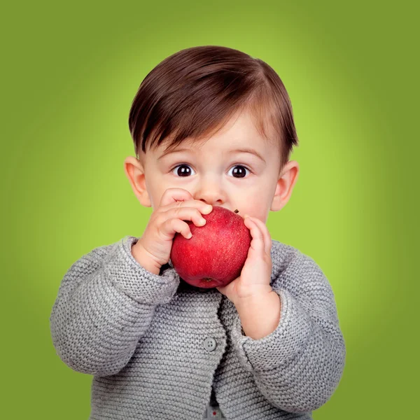 Adorable baby eating a red apple — Stock Photo, Image