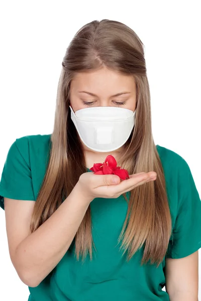 Allergic teen with face mask looking red petals — Stock Photo, Image