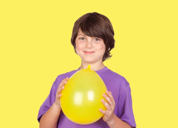Adorável menino pré-adolescente com um balão amarelo — Fotografia de Stock