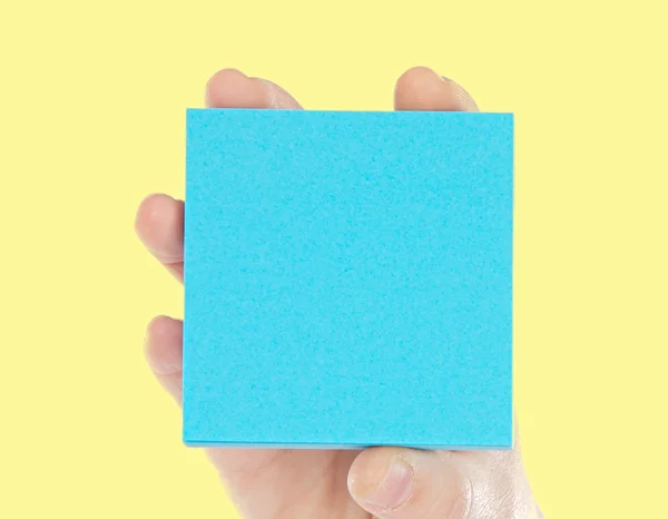 Mano sosteniendo un papel azul para notas — Foto de Stock