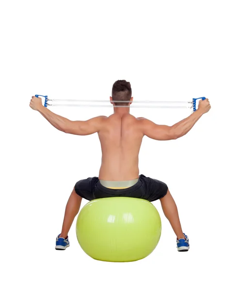 Homem forte praticando exercícios com halteres sentar em uma bola — Fotografia de Stock