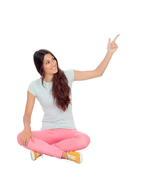 Casual girl sitting on the floor pointing something — Stock Photo, Image