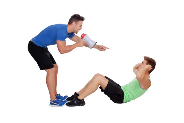Personal trainer with a megaphone and boy making abdominal — Stock Photo, Image