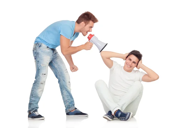 Jonge mannen schreeuwt aan zijn vriend via een megafoon — Stockfoto