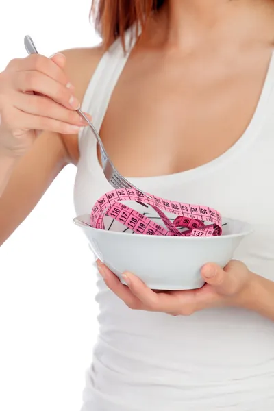 Slim woman eating with a scale in the plate — Stock Photo, Image