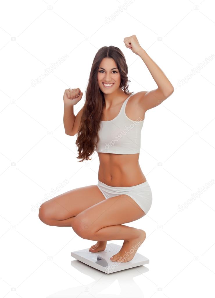 Happy woman celebrating her new weight on a scale
