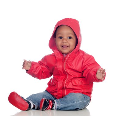 Kırmızı yağmurluk ile katta oturan Afrika bebek
