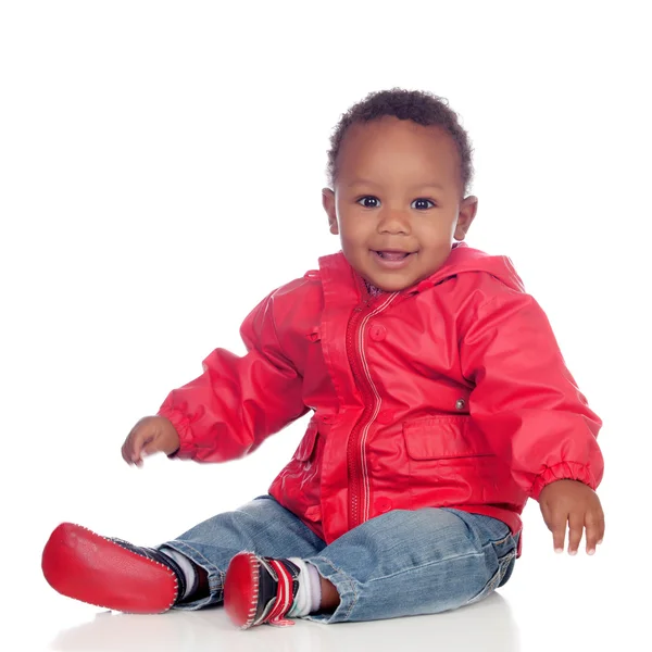 Adorável bebê africano sentado no chão com capa de chuva vermelha — Fotografia de Stock