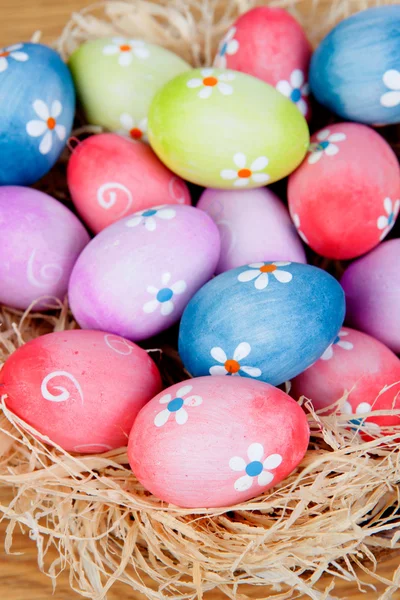 Easter eggs decorated with daisies on a nest of straw — Stock Photo, Image