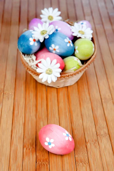 Easter eggs decorated with daisies tucked in a basket — Stock Photo, Image