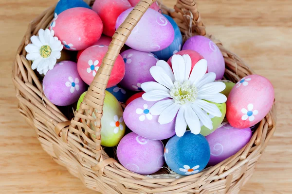 Easter eggs decorated with daisies tucked in a basket — Stock Photo, Image