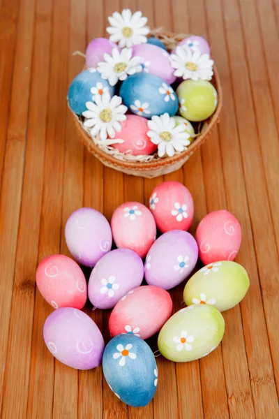 Easter eggs decorated with daisies tucked in a basket — Stock Photo, Image