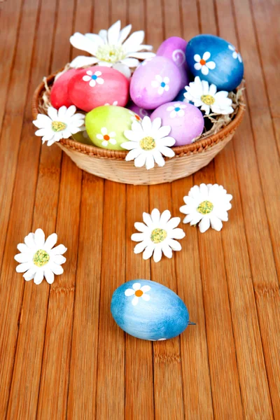 Easter eggs decorated with daisies tucked in a basket — Stock Photo, Image