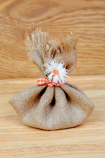 Brown bag closed with a ribbon and a flower — Stock Photo, Image