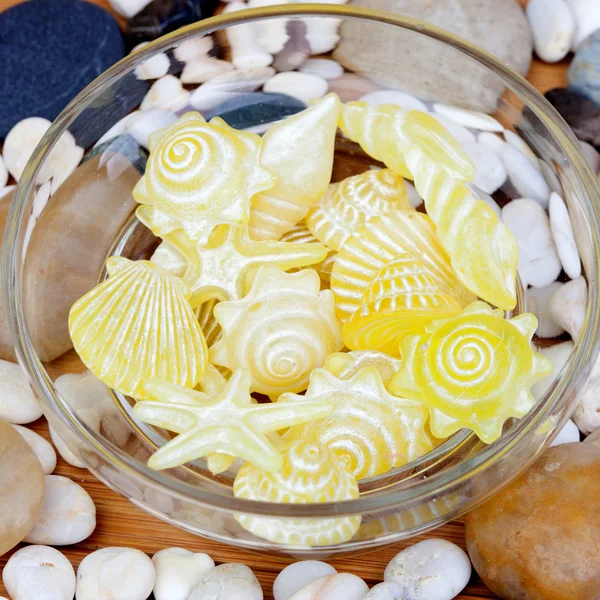 Желтое мыло с раковинами и морскими звездами и много маленьких — стоковое фото