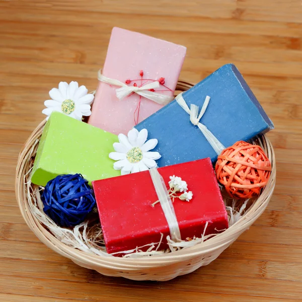 Handmade soaps on a basket decorated with flowers — Stock Photo, Image