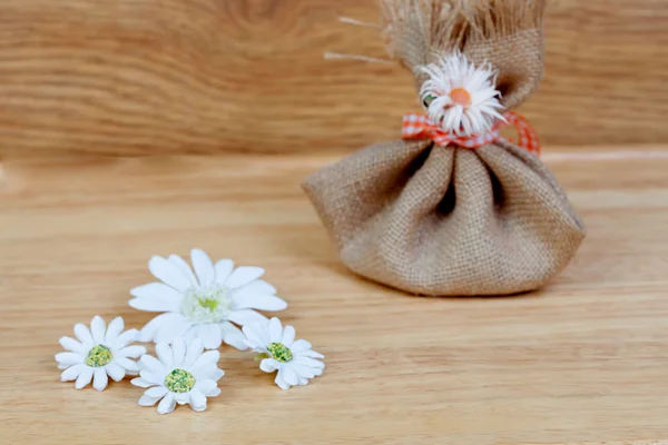 Brown bag closed with a ribbon and flowers — Stock Photo, Image