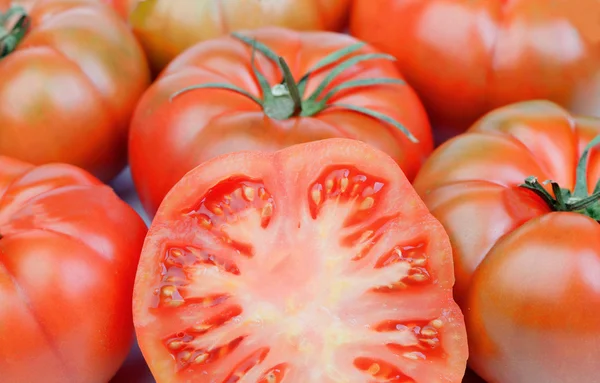 Close-up of a cracked tomato tomatoes surrounded — Stock Photo, Image