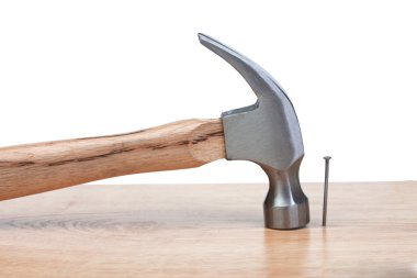 Hammer hitting a nail into a wood