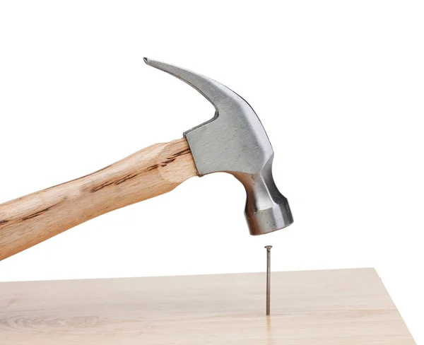 Hammer hitting a nail into a wood — Stock Photo, Image