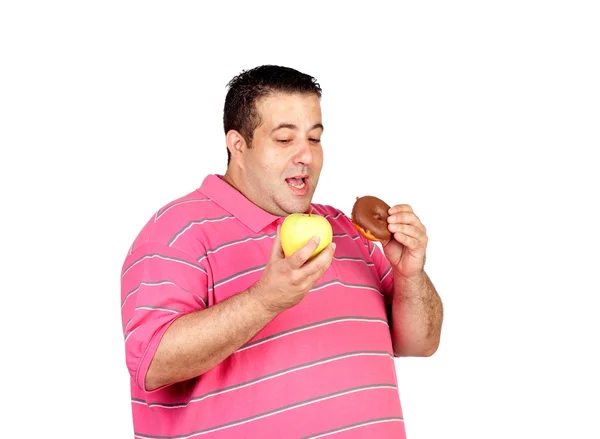 Gordo decidindo entre uma maçã e um doce — Fotografia de Stock