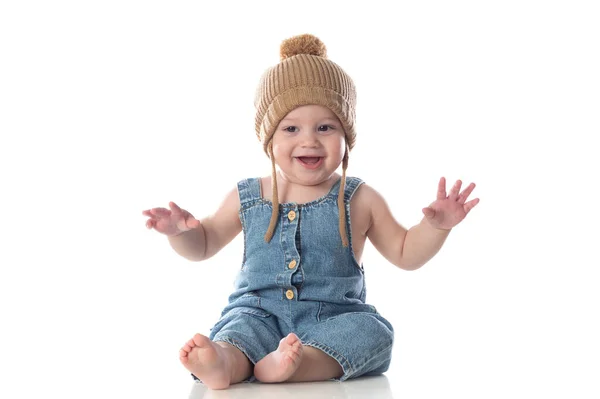 快乐的婴儿 戴着一顶皱巴巴的帽子 坐在孤零零的地板上 — 图库照片