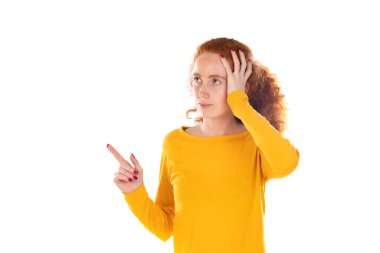 Genç, güzel bir kadın kendinden emin bir şekilde gülümsüyor. Beyaz arka plana karşı pozitif, rahat ve tatmin edici bir tavır sergiliyor.