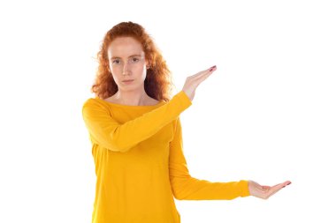 Kızıl saçlı kız ellerinde beyaz bir arka planda izole edilmiş bir şey tutuyor.