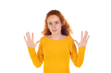 Şok olmuş, kendine güveni olmayan kızıl saçlı kadın beyaz arka planda masum bir şekilde elini kaldırdı.