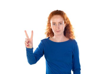 Çekici, kızıl saçlı, neşeli bir kızın portresi beyaz arka planda izole edilmiş bir şekilde eğleniyor. 