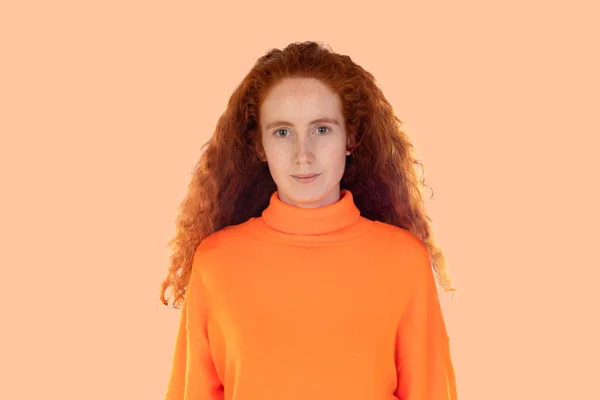 Pensive Rothaarige Mädchen Isoliert Auf Einem Orangefarbenen Hintergrund — Stockfoto