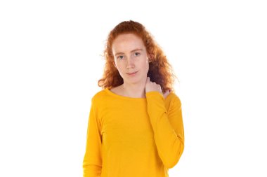 Sırt ağrısı çeken genç, kızıl saçlı bir kadın. Omzuna eliyle dokunuyor. Beyaz arka planda izole edilmiş kas ağrısı.