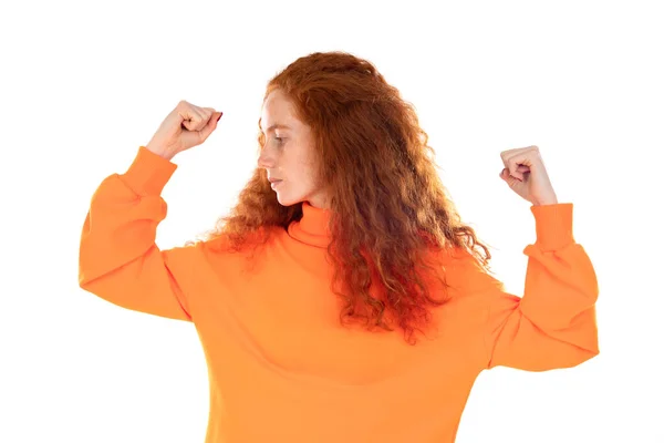 身穿橙色毛衣 头戴白色背景的红头发少女微笑着举手表决肌肉 自信胜利 坚强而独立 — 图库照片