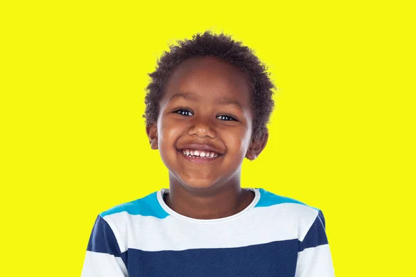 穿着T恤衫的非洲孩子看着摄像机 在黄色的背景下独自笑着 — 图库照片