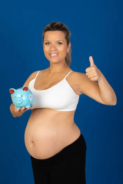 妊娠中 青い背景に孤立したお金箱を持つ幸せな妊婦 — ストック写真