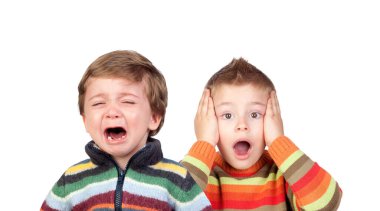 Two funny small brothers showing emotions isolated on a white background