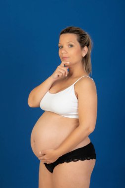Pregnant happy woman in underwear isolated on a blue background