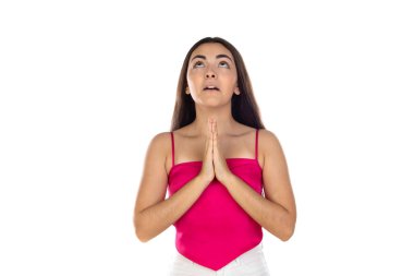 Esmer kadın, dua eden elleriyle beyaz arka planda duruyor.