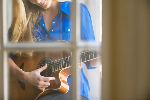 Giovane donna che suona la chitarra sulla finestra — Foto Stock