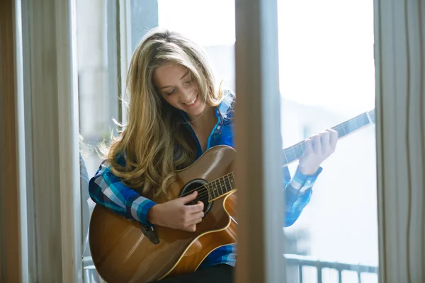 年轻女子在窗口上弹吉他 — 图库照片