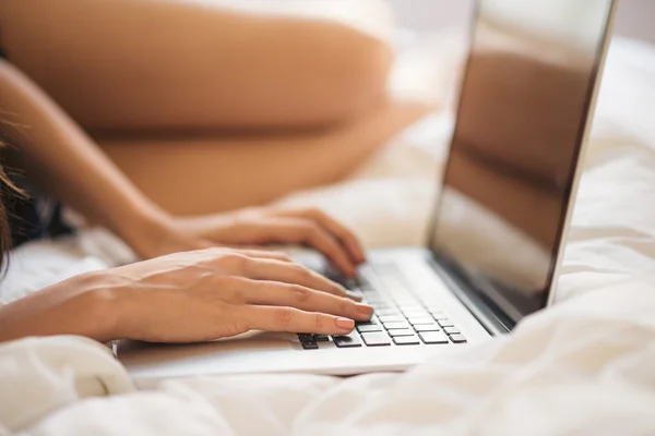 Typing on the laptop in bed — Stock Photo, Image