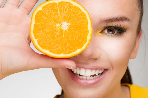 Young brunette with orange in her hand — Stock Photo, Image