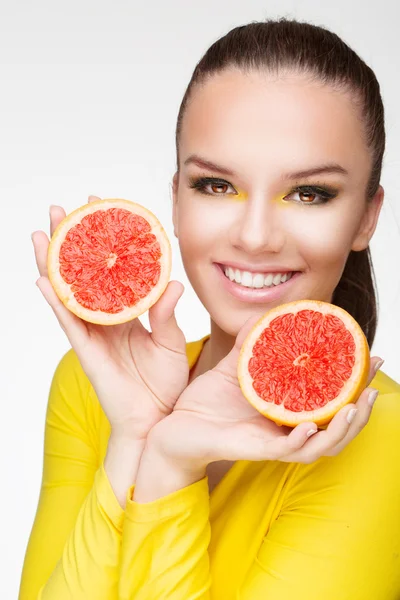 Young brunette with red grapefruit in her hand — Stock Photo, Image