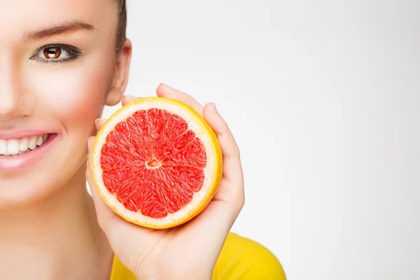 Young brunette with red grapefruit in her hand — Stock Photo, Image