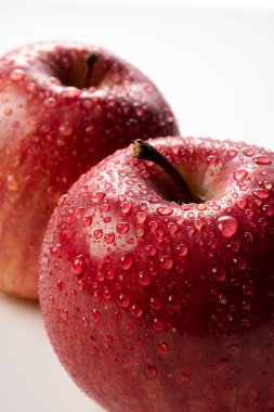 Beyaz arka planda su damlaları olan elmalara yakın çekim. Tatlı resmi, diyet.