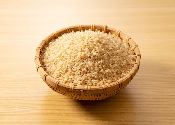 用竹子做的糙米放在木制的背景上 一堆糙米 — 图库照片