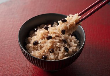 Kırmızı tepsiye konmuş kırmızı pirinç. Sekihan haşlanmış fasulyeli buğulanmış glutinous pilavıdır..